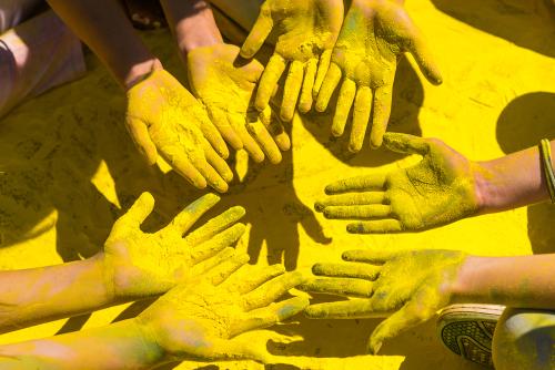 Hands with yellow pigment powder