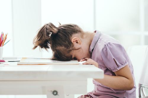 Girl with head on table, tired of reading