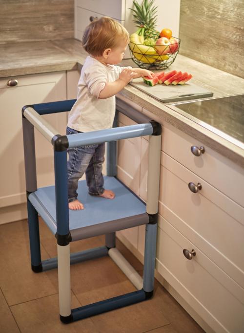 Boy on learning tower grabs melon